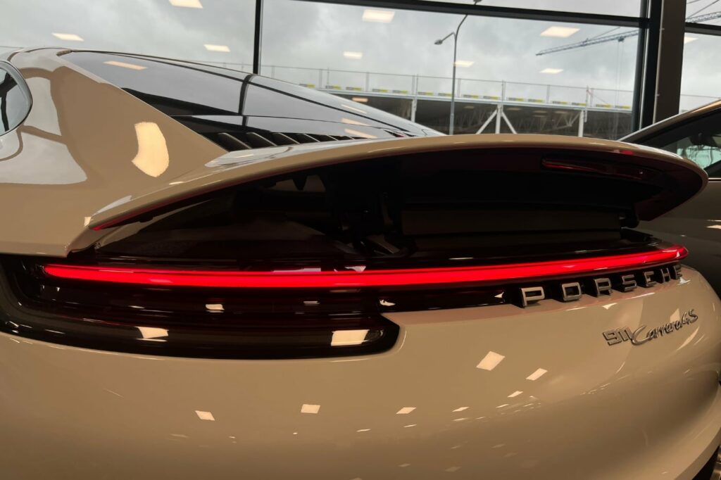 Närbild på lampa och bilmärke på en Porsche Carrera